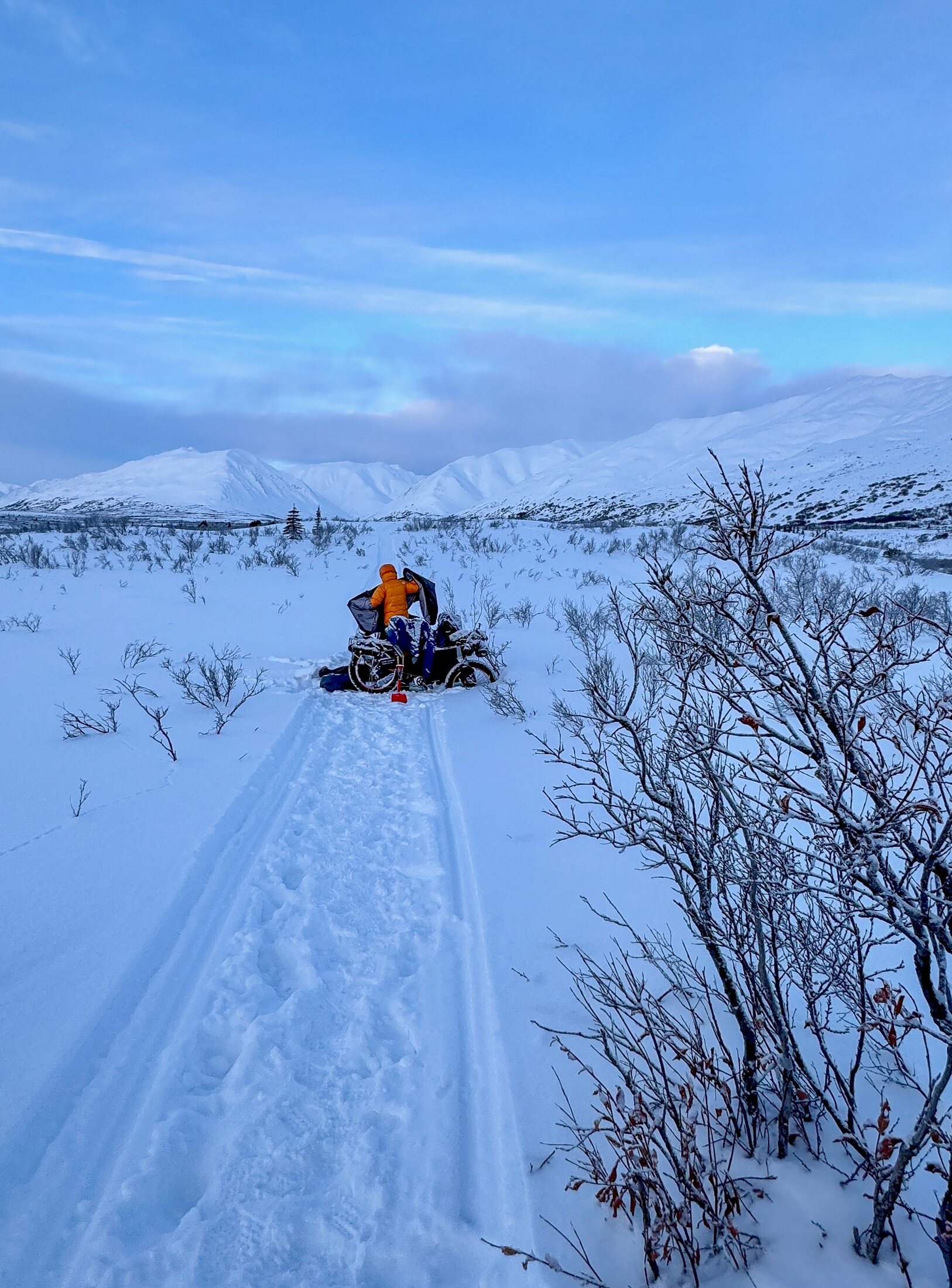 Alessandro Plona che spinge la bici carica di bagagli nella neve fresca in Alaska